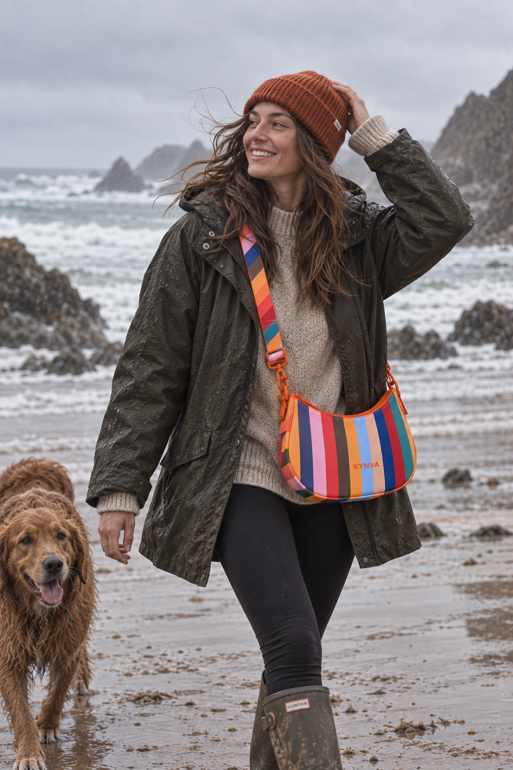 KYNVA Rainbow Stripe waterproof crossbody bag worn on a rainy coastal dog walk in Cornwall